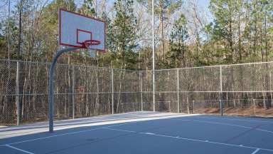 an image of a shaded fenced in basketball court